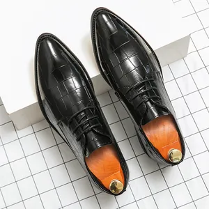 Detalle de zapatos de vestir negros con punta y grabado de cocodrilo