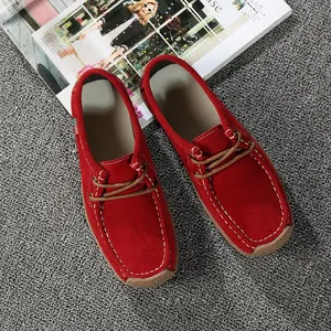 Vue de dessus de mocassins rouges en daim pour femme avec détails de surpiqûres blanches contrastées