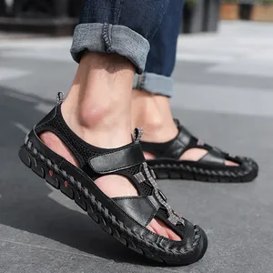 Gedetailleerd zicht op ademende zwarte leren outdoorsandalen voor heren met handstiksels.