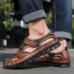 Close-up van bruine handgemaakte outdoor sandalen voor heren met ademend mesh en stiksels