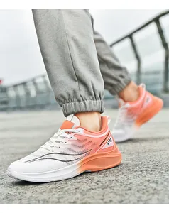 Detailweergave van ademende mesh hardloopschoenen met een oranje kleurverloop