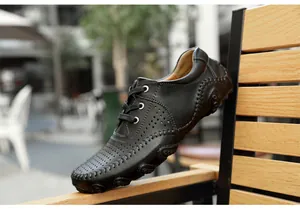 Side view detail of men's black leather loafers with unique octopus sole and breathable holes.
