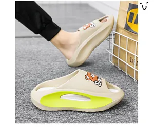 Dettaglio di ciabatte beige con suola spessa, orsetto cartoon e accenti verde lime