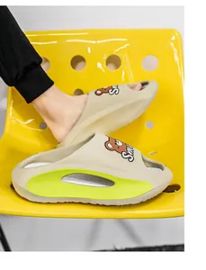 Dettaglio della vista laterale di ciabatte beige con orsetto e suola cava verde lime