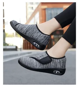 Detailed side view of grey knit walking shoes featuring air cushion and velcro strap