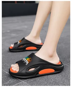 Nahaufnahme stilvoller schwarz-orangefarbener Strand-Slipper mit dicker, gepolsterter Sohle