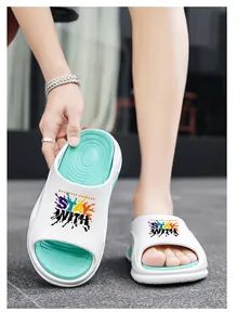 Detailansicht der weiß-mintgrünen Slipper mit dicker Sohle und bunter Grafikaufdruck