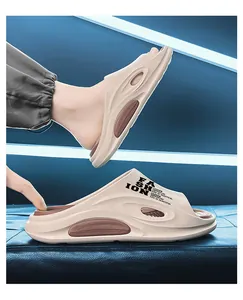 Detailansicht stilvoller beiger Slipper mit FASHION-Aufdruck und Komfortsohlen.