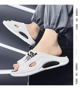 Nahaufnahme von weißen Freizeit-Slippern mit 'Fashion'-Druck und weicher dicker Sohle.