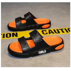 Detailansicht modischer schwarz-oranger Sport-Sandalen mit dicker weicher Sohle und Textaufdruck