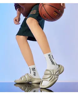 Close-up of basketball-textured athletic slides with thick cushioning on a model's feet.