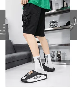 Vista dettagliata di ciabatte nere da uomo alla moda con simpatico orsetto.