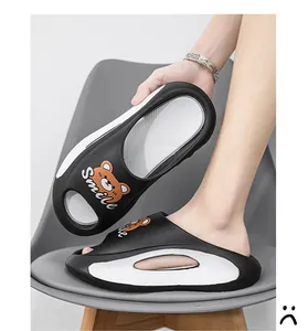 Vista laterale di ciabatte nere platform con orsetto cartoon e scritta Smile
