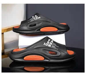 Detailansicht der schwarz-orangen Partner-Sandalen mit weißem „FASHION“-Aufdruck an der Seite.