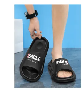 Primo piano di ciabatte nere a suola spessa con stampa Smile per uso interno ed esterno