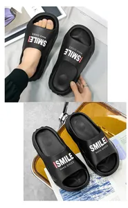 Vista dettagliata di ciabatte nere a suola spessa con stampa Smile e morbido materiale EVA