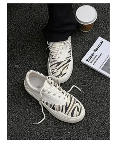 Detailansicht der cremefarbenen Canvas-Sneaker mit modischen Tigerstreifen-Einsätzen