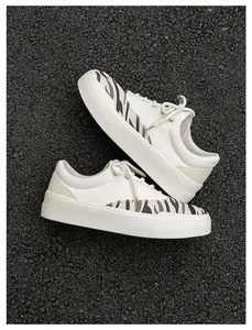 Detailansicht von cremefarbenen Canvas-Sneakern mit stilvollen Zebra-Print-Einsätzen