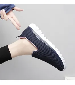 Détail de mocassin en maille respirante bleu marine avec semelle blanche au pied