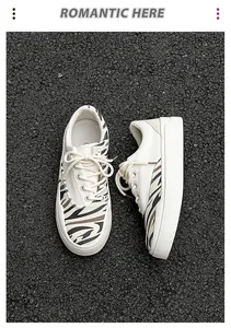 Detailansicht von oben auf weiße Canvas-Sneaker mit Zebra-Print und Plateausohle