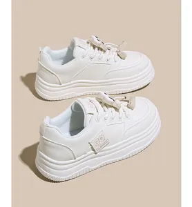 Detailed view of white platform sneakers featuring cute cartoon charms and thick soles.