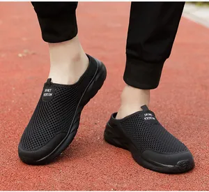 Gedetailleerd overzicht van ademende zwarte mesh herensneakers op een atletiekbaan.