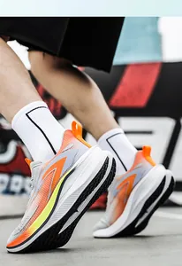 Close-up of vibrant orange and grey breathable mesh running shoes worn on feet
