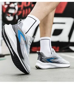Detailed side view of grey breathable mesh running shoes with blue accents on pavement