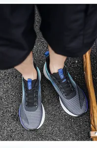 On-foot top-down view of breathable mesh athletic running shoes on asphalt surface