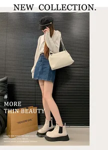 Detailed view of stylish off-white chunky Chelsea boots for women in a chic street style look