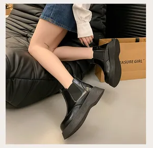 Detail view of stylish women's black platform Martin boots with chunky soles on a model