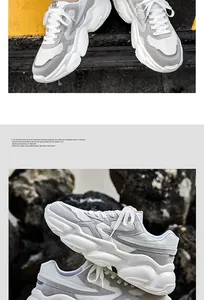 Detailed close-up of white and grey chunky retro sneakers for men with breathable mesh fabric.