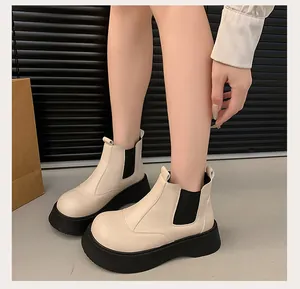 Detail of women's beige platform Chelsea boots with thick black soles for autumn winter
