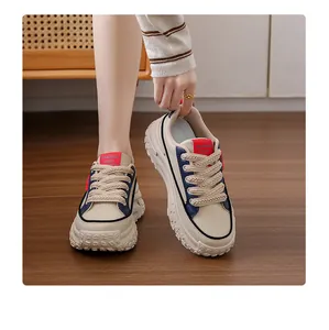 Close-up detail of stylish beige chunky sneakers with textured soles and woven laces