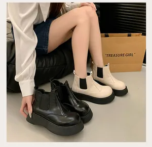 Detailed view showing women's chunky platform Chelsea boots in black and cream leather