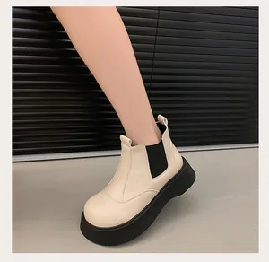 Side view detail of stylish cream platform Chelsea boots featuring black elastic panels