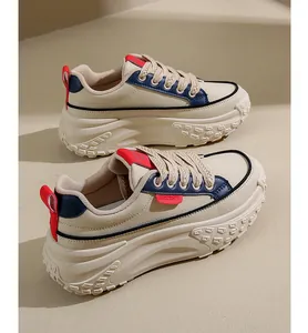 Side view of beige chunky platform sneakers with blue and red details for women.