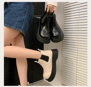 Detail view of stylish women's black and beige platform Chelsea boots with thick soles
