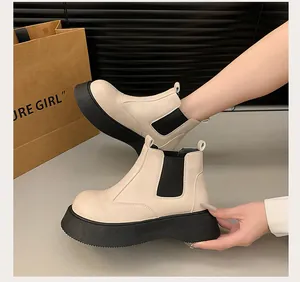 Detail shot of women's beige platform Chelsea boots with thick black soles.