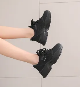 Side view detail of black chunky dad sneakers with thick platform soles and mesh upper