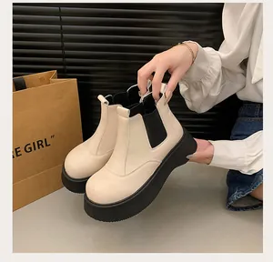 Side view of stylish women's beige platform Chelsea boots with thick black rubber soles