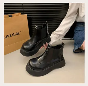 Close-up of black platform Chelsea boots with thick soles and vintage round toe style