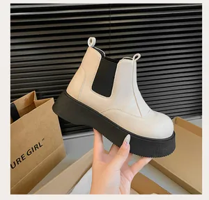 Detail shot of beige platform Chelsea boots featuring thick black soles and elastic panels