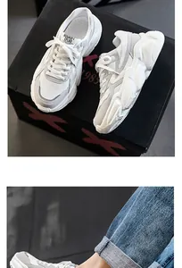 Detail view of white chunky retro sneakers with breathable mesh upper and thick soles