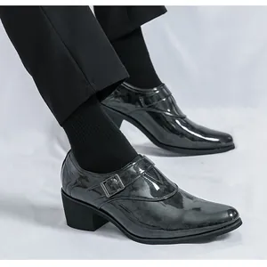 Detail von schwarzen Herren-Lacklederschuhen mit spitzer Kappe, Schnalle und Absatz.