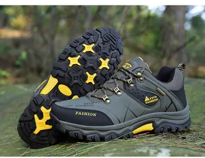Dettaglio di scarpe da trekking da uomo verde oliva con suole gialle resistenti