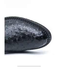 Detailed macro shot of premium black ostrich leather texture on men's pointed toe boot