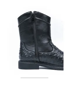 Side view of men's black cowboy boots with ostrich leather texture and zipper detail