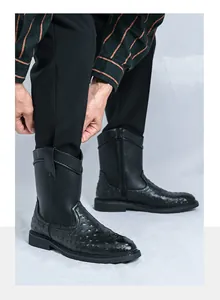 Macro view of men's black high-top cowboy boots featuring unique ostrich skin texture