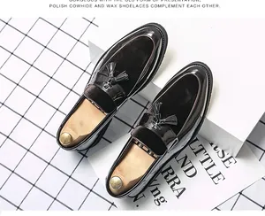 Detailed macro view of polished cowhide loafers with elegant tassels and premium wooden shoe trees